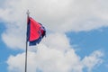 Red flag with blue fringe on metal pole