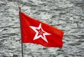 Red flag with five-pointed star and hammer and sickle on background of water