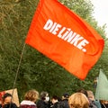 Red flag of German leftist party, die Linke, flies over heads of demonstrators