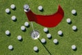 Red flag on green with many golf balls. Royalty Free Stock Photo