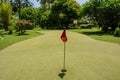 Red flag in the hole at the golf field Royalty Free Stock Photo