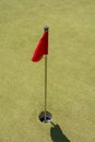 Red flag in the hole at the mini golf field Royalty Free Stock Photo