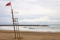 A red flag in a lifeguard tower warn swimmers of danger of bathing in the beach Royalty Free Stock Photo