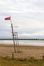 A red flag in a lifeguard tower warn swimmers of danger of bathing in the beach Royalty Free Stock Photo