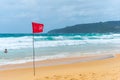 Red flag no swimming here sign at beach in windy day Royalty Free Stock Photo