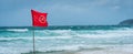 Red flag no swimming here sign at beach in windy day Royalty Free Stock Photo