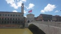 The red flag of Pisa waving in the wind on the main bridge on the Arno river in the city centre of Pisa