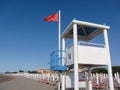 Red flag for rough sea over a lifeguard tower long an Italian be