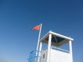 Red flag for rough sea over a lifeguard tower long an Italian be Royalty Free Stock Photo