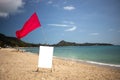 Red flag and a sign with a copy space on a tropical beach on a nice day. Royalty Free Stock Photo