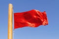 Red flag to develop on the background of blue sky Royalty Free Stock Photo