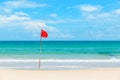 Red flag on tropical beach Royalty Free Stock Photo