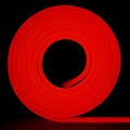 Red flexible glowing led tape neon in reel standing on black background Royalty Free Stock Photo