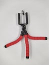 red and flexible tripod for phone on white background Royalty Free Stock Photo