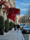 Red floral vines hang over the awning of the hotel Royal Monceau, Paris, France