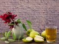 Red flower with green leaves  in  small vase  , green apples and apple juice on wooden table Royalty Free Stock Photo