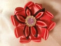 red flower made of satin in the middle, slightly black and beaded in the middle