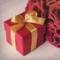 Red flowers and gift box with yellow ribbon Royalty Free Stock Photo