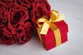 Red flowers and gift box with yellow ribbon Royalty Free Stock Photo