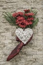 Red flowers hanged on a wall with white heart Royalty Free Stock Photo
