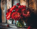 Red flowers in vase on wooden background. Mothers Day concept