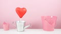 The red foiled chocolate heart stick with small silver watering can and small pink bucket Royalty Free Stock Photo
