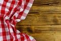 Red folded checkered napkin on rustic wooden kitchen table. Top view, copy space Royalty Free Stock Photo