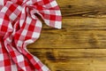Red folded checkered napkin on rustic wooden kitchen table. Top view, copy space Royalty Free Stock Photo