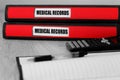 Red folders with medical records written on the label on a desk