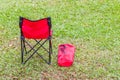 The red folding chair and cover on green grass.