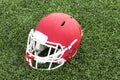 Red football helmet on a green turf field Royalty Free Stock Photo