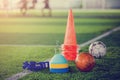 Red football and soccer training equipment on artificial turf.