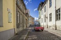 A red Ford Mustang convertible drives by a narrow cobbled street in the Old Town of Tallinn Royalty Free Stock Photo