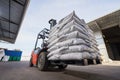 Red forklift lifts pallet with heavy bags