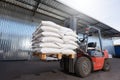 Red forklift lifts pallet with heavy bags