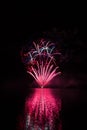 Red fountain and color sparkles from rich fireworks over Brno`s Dam with lake reflection Royalty Free Stock Photo