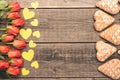 Red flowers, gingerbread and yellow hearts on old boards. Nice and warm light. Free space. Royalty Free Stock Photo