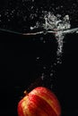 Red fresh apple falling into the water with splash Royalty Free Stock Photo