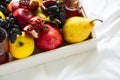 Red fresh juice with apples, pears, bananas, grapes and pomegranate fruits in white wooden tray on bed sheet. Top view. Healthy l Royalty Free Stock Photo