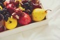 Red fresh juice with apples, pears, bananas, grapes and pomegranate fruits in white wooden tray Royalty Free Stock Photo