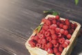 Red fresh raspberries basket on brown rustic wood background Royalty Free Stock Photo