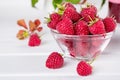 Red fresh raspberries in a glass bowl with green leaves Royalty Free Stock Photo