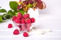 Red fresh raspberries in a glass bowl with green leaves Royalty Free Stock Photo