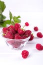 Red fresh raspberries in a glass bowl with green leaves Royalty Free Stock Photo