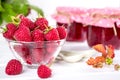 Red fresh raspberries in a glass bowl and Raspberry jam with green leaves Royalty Free Stock Photo