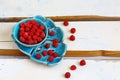 Red fresh raspberries on white rustic wood background. blue bowl natural ripe organic berries, top view with copy space Royalty Free Stock Photo