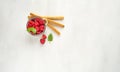 Red fresh raspberries on white rustic wood background. Bowl with natural ripe organic berries with green mint leaves on Royalty Free Stock Photo