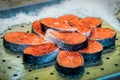 Red fresh raw fish on ice, sold in the supermarket. A steak and fillet of red salmon fish are on the counter of a fish store Royalty Free Stock Photo