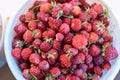 Red fresh strawberry with green leaves in white bucket from above