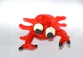 A red frog made of plasticine. Plasticine toys on white background